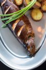 De cima peixe frito delicioso e batatas com cebolinha fresca e molho de creme colocado em placa de metal no restaurante — Fotografia de Stock