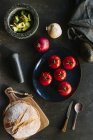 Вид сверху на разнообразные овощи и хлеб, поставленные рядом с тарелкой с вкусной гуакамоле на кухне — стоковое фото
