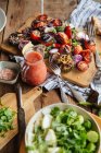From above of aromatic delicious grilled vegetables including red tomatoes and pepper with sliced eggplants and onion served on wooden board on rustic table with homemade dishes — Stock Photo