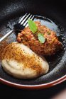Dall'alto deliziosa carne macinata fritta con spinaci e salsa alla panna posta in ciotola nera — Foto stock