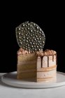 Festlich geschnittener Kuchen mit Schokoladenfüllung und Zuckerguss und silberner Isomaltdekoration auf Tisch mit schwarzem Hintergrund — Stockfoto
