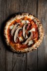 Draufsicht auf hausgemachte Pizza mit geschnittenen Pilzen und Tomaten mit Käse auf hölzernem Hintergrund — Stockfoto