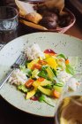 Верхний вид аппетитного красочного салата со свежими овощами и фруктами и измельченной курицей, подаваемой в миске — стоковое фото