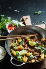 Draufsicht auf appetitliche orientalische würzige Rührbraten mit Zucchini und rotem Pfeffer garniert mit frischer Limette und Koriander — Stockfoto