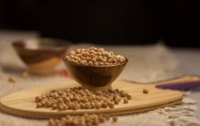 Montón de garbanzos crudos colocados sobre tabla de madera en la cocina - foto de stock