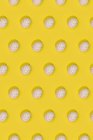 Безшовний великодній візерунок з кольоровими прикрашеними яйцями, розташованими рядами на жовтому тлі — стокове фото