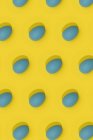 Modèle de Pâques sans couture avec des œufs décorés colorés disposés en rangées sur fond jaune — Photo de stock