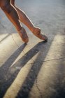 Immagine ritagliata di ballerina di balletto femminile in punti con livido sulla gamba in piedi in punta di piedi durante l'esecuzione di esercizi classici durante l'allenamento in studio — Foto stock