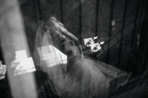 From below double exposure of young female dancer in ballet tutu standing in blinks of light in modern studio — Stock Photo