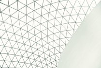From below geometric dome ceiling of with many triangular parts inside of white futuristic building in city — Stock Photo