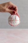 Ritagliato persona irriconoscibile in possesso di un dolce russo tradizionale Zefir bianco fatto in casa avvolto con corda su sfondo rosa — Foto stock