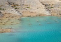 Чистая вода водохранилище расположен между побережьем с сухой травой и грубой горы в облачный день в Альхесирас, Испания — стоковое фото
