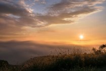 Величественный горный хребет на фоне пасмурного неба в природе во время заката — стоковое фото