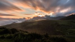 Величний гірський хребет проти похмурого неба в природі під час заходу сонця — стокове фото