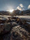 Vista de tirar o fôlego do cume da montanha coberto com neve branca localizada contra o vívido céu de pôr-do-sol à noite nublado na natureza — Fotografia de Stock