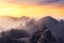 Raue Gebirgskette vor hellem Sonnenaufgang am nebligen Morgen in der Natur — Stockfoto