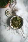 Draufsicht auf Schüssel mit vorbereiteten unreifen Sojabohnen auf Marmortisch in der Nähe von Stoffservietten und Gewürzen — Stockfoto