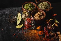 From above composition with different kinds of natural aromatic spices placed on slate surface background — Stock Photo