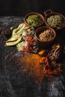 Top view composition with different kinds of natural aromatic spices placed on slate surface background — Stock Photo