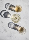 Vista dall'alto composizione di vari bicchieri con bevande alcoliche alla luce del sole lasciando ombre e luci sulla superficie di marmo — Foto stock