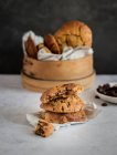 Стек смачного шоколадного печива з кусаним шматочком, розміщеним на столі біля дерев'яної миски зі свіжою домашньою випічкою — стокове фото