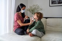 Mutter legt Beatmungsgerät für ihr Kind an, um mögliche Infektionen zu vermeiden — Stockfoto