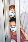 Mother and child looking out their home window to see if the danger of possible infection has passed — Stock Photo