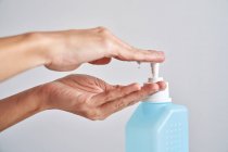 Женщина чистит руки антисептическим гелем, чтобы предотвратить инфекцию — стоковое фото