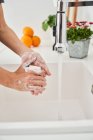 Woman washing her hands on the kitchen sink to avoid possible infection — Stock Photo