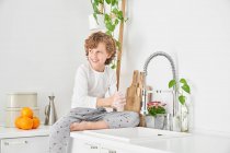 Blondes Kind wäscht sich die Hände in der Spüle, um Infektionen vorzubeugen — Stockfoto