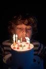 Ragazzo biondo soffiando le candele sulla sua torta di compleanno di carta igienica — Foto stock
