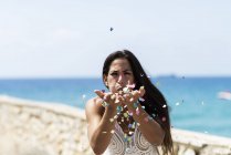 Mulher festa ao ar livre à beira-mar se divertindo olhando câmera — Fotografia de Stock