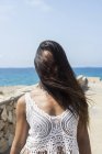 Donna ispanica dai capelli lunghi copre il viso da lunghi capelli dal vento all'aperto — Foto stock