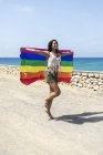 Porträt einer hübschen hispanischen Frau, die mit einer lgtb-Flagge spielt — Stockfoto