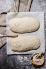 De cima vista superior pão artesanal em uma mesa polvilhada com farinha branca — Fotografia de Stock