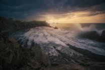 Magnifico scenario di costa rocciosa e onde travagliate di schiuma oceanica durante il tramonto — Foto stock