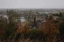 Desde arriba paisaje urbano de la vieja ciudad de Edimburgo con edificios de piedra bajo el cielo gris brumoso en el día de otoño - foto de stock