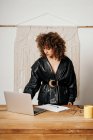 Femme entrepreneur corps complet en tenue rétro navigation ordinateur portable pendant le travail au bureau — Photo de stock