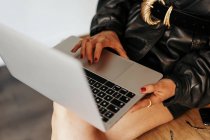 Imagem cortada de empreendedor em roupa retro sentado na mesa e laptop de navegação durante o trabalho no escritório — Fotografia de Stock