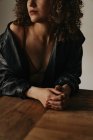 Mulher sensual em jaqueta de couro e sutiã com cabelo encaracolado no quarto — Fotografia de Stock