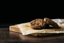 Tasty chocolate cookies on wooden table — Stock Photo