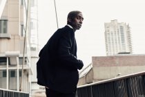 Empresario negro caminando por el camino de la ciudad - foto de stock
