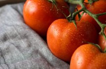 From above of wet clean tomatoes placed on gray fabric napkin on grey concrete table background — Stock Photo