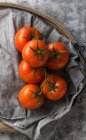 Von oben Ansicht der nassen sauberen Tomaten auf grauer Stoffserviette auf grauem Betontischhintergrund — Stockfoto