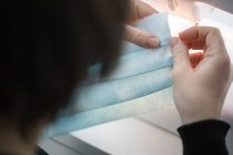 Mujer haciendo mascarillas para pandemia de coronavirus - foto de stock