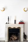 Rustikaler Kamin mit Dekorationen oben im gemütlichen Wohnzimmer in stilvoller Wohnung — Stockfoto