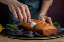 Обрезанные неузнаваемые женские руки разрезанные ножом домашний лимонный торт — стоковое фото