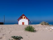 Маленький будинок на березі моря з блакитним небом — стокове фото