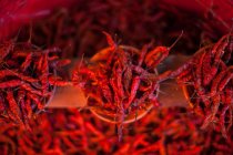 Vue de dessus des piments rouges séchés disposés dans des pots à vendre sur le marché — Photo de stock