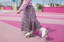 Стильна молода жінка на ковзанах позує на дитячому майданчику — стокове фото